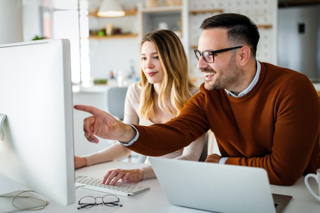 Equipa de designers a discutir ideias junto a um computador portátil